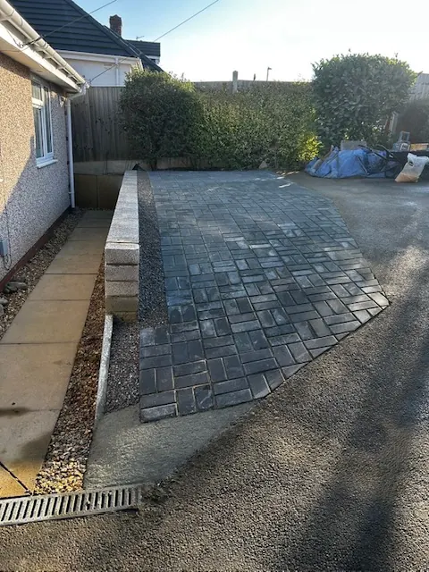 Newly laid grey block paved drive beside a bungalow. One of our jobs.