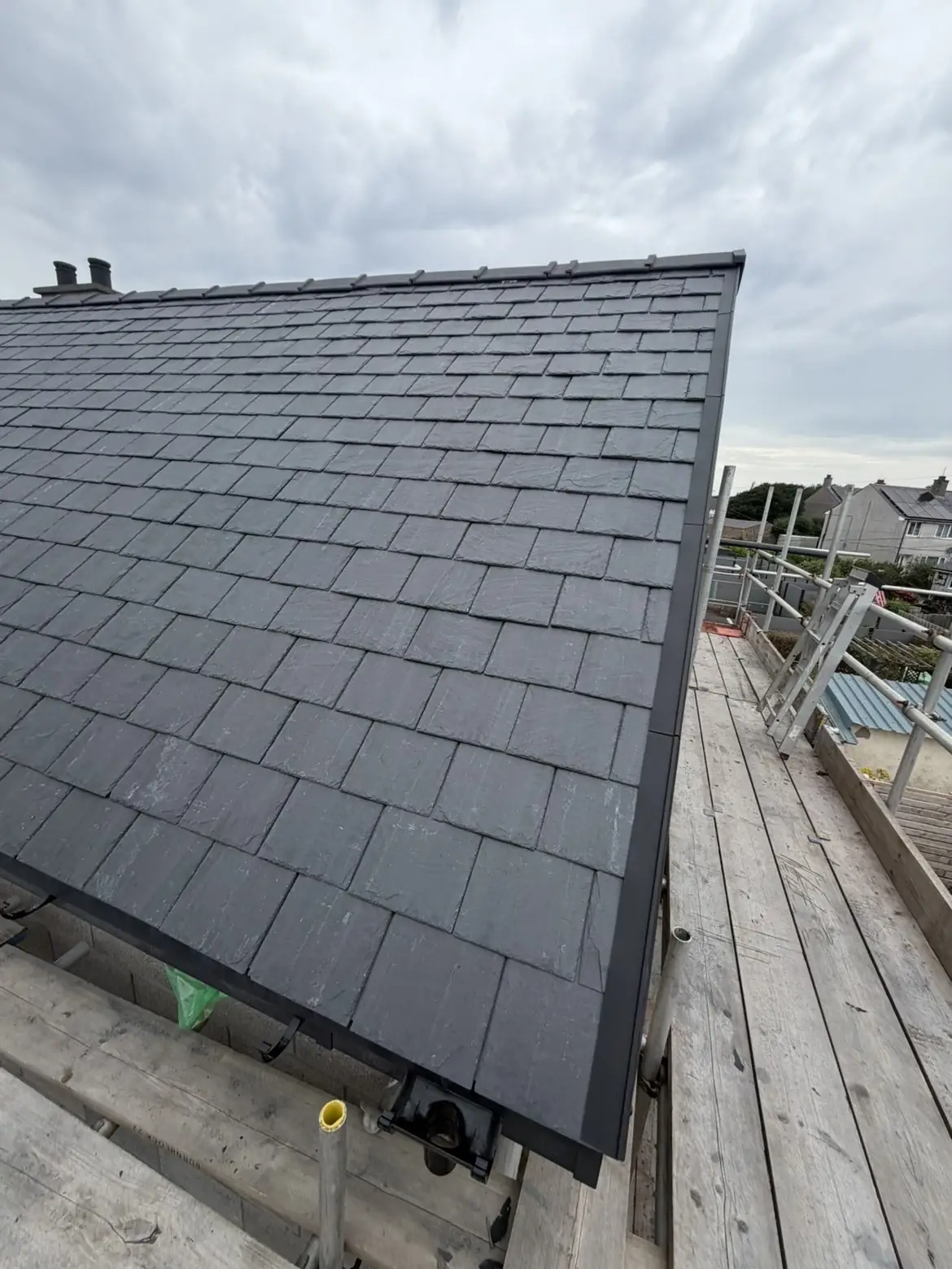 Newly laid slate roof seen from the scaffold boards. One of our jobs.
